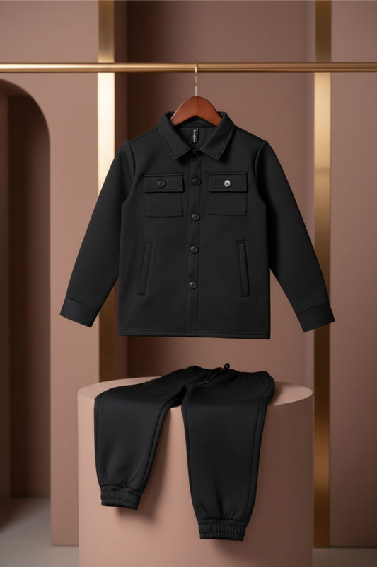 Black jacket and pants set on a pink pedestal against a gold and pink background