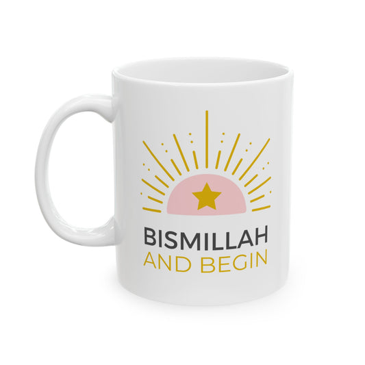 White mug with pink and gold sunrise design and text “Bismillah and Begin” in bold, modern typography.