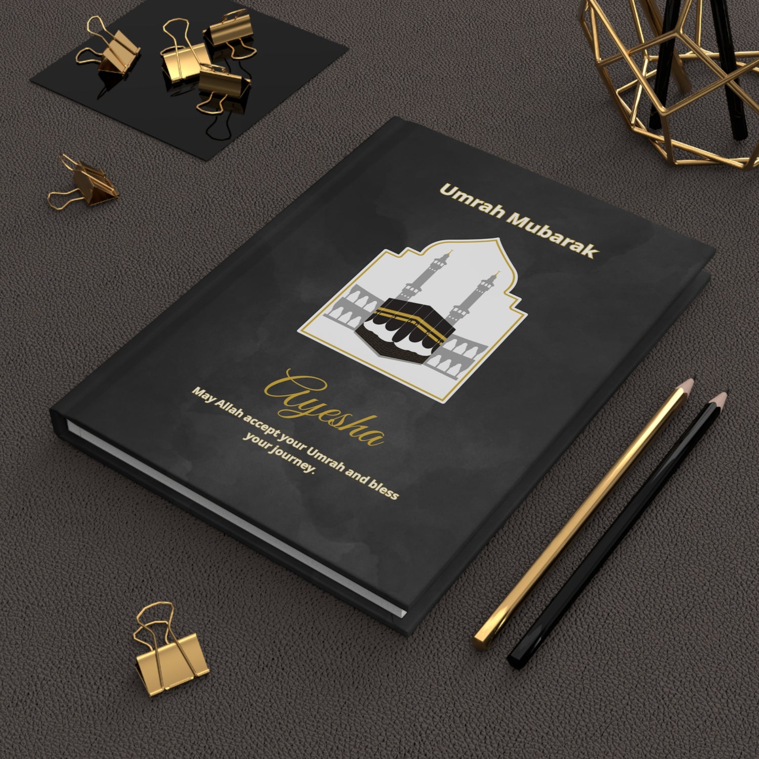 Personalized Umrah notebook with Kaaba illustration, dua in Arabic and English, and name Ayesha on matte black hardcover