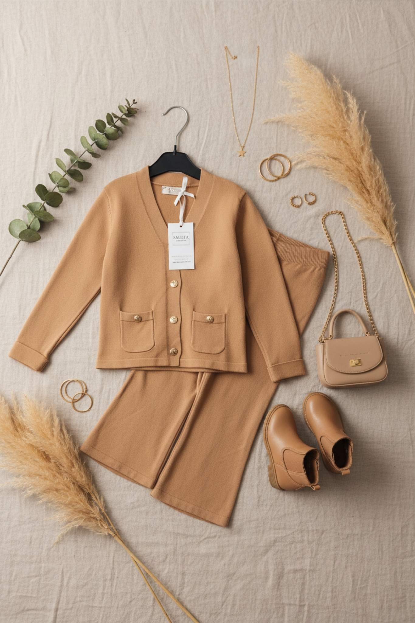 Beige outfit with jacket, pants, shoes, and accessories on a neutral background
