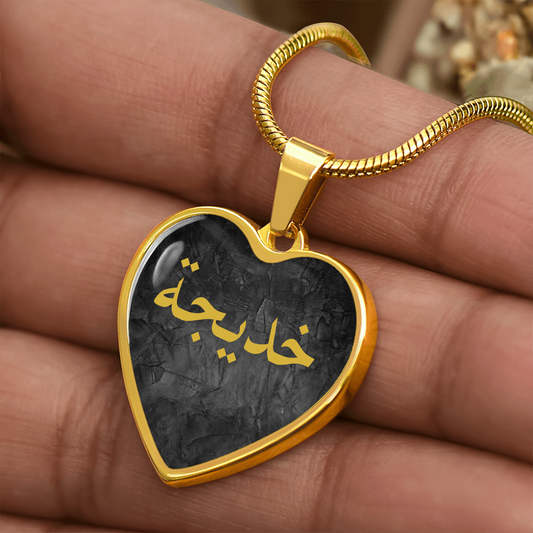 Gold heart-shaped Arabic name necklace with black background and gold lettering – custom Islamic jewelry gift for her