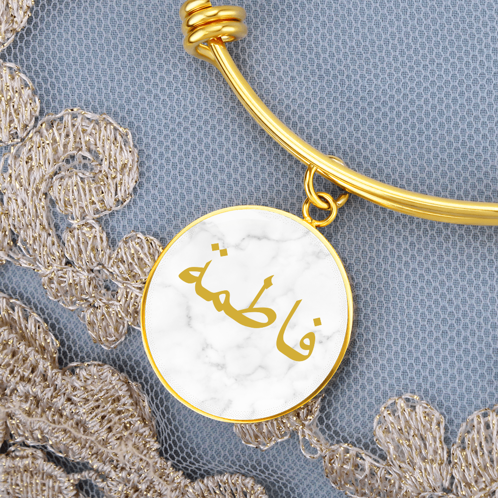 Round gold bracelet with Arabic name engraved in gold on a white marmer background – Islamic personalized jewelry for women